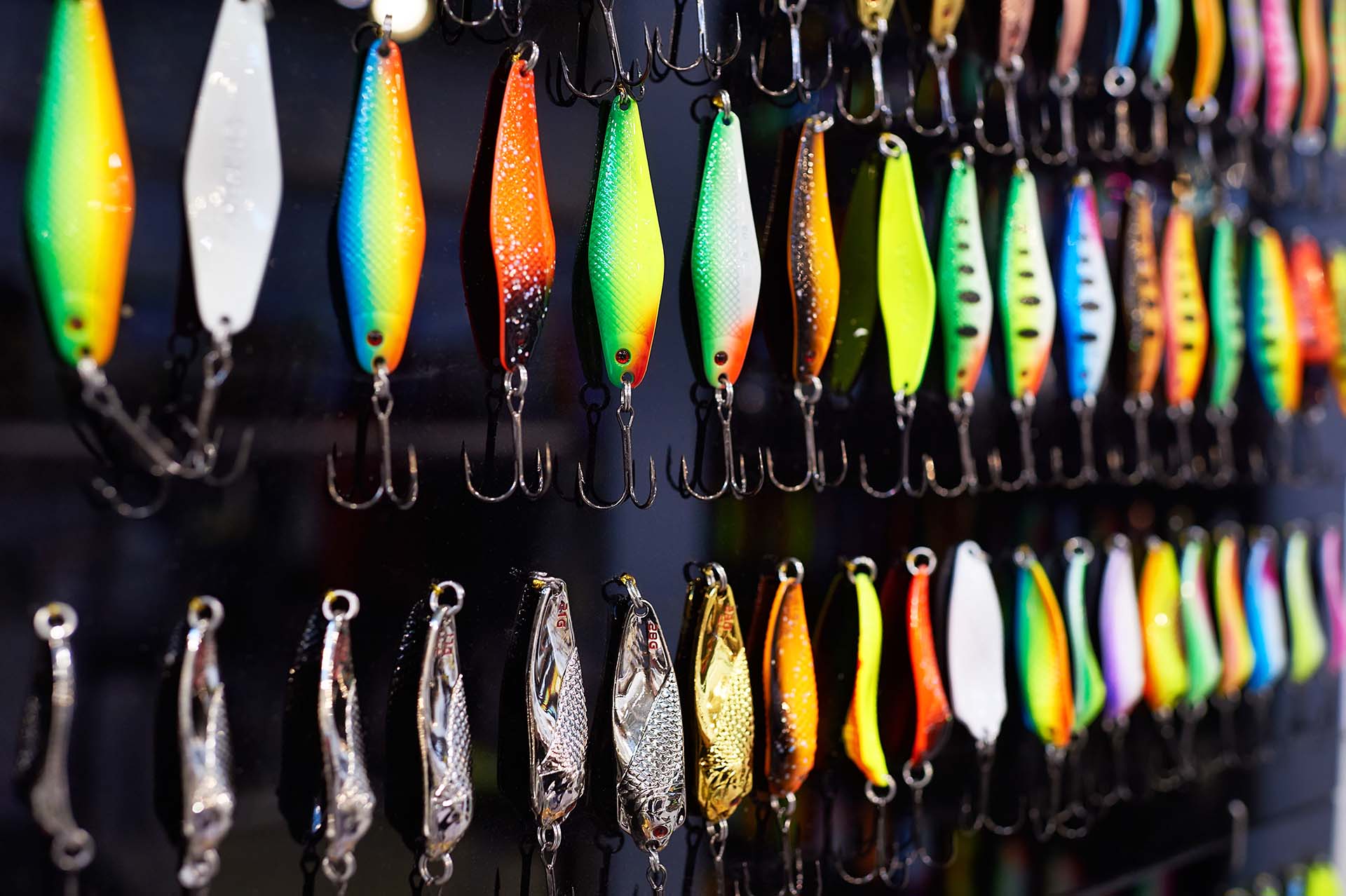 Different colorful fishing baits on black