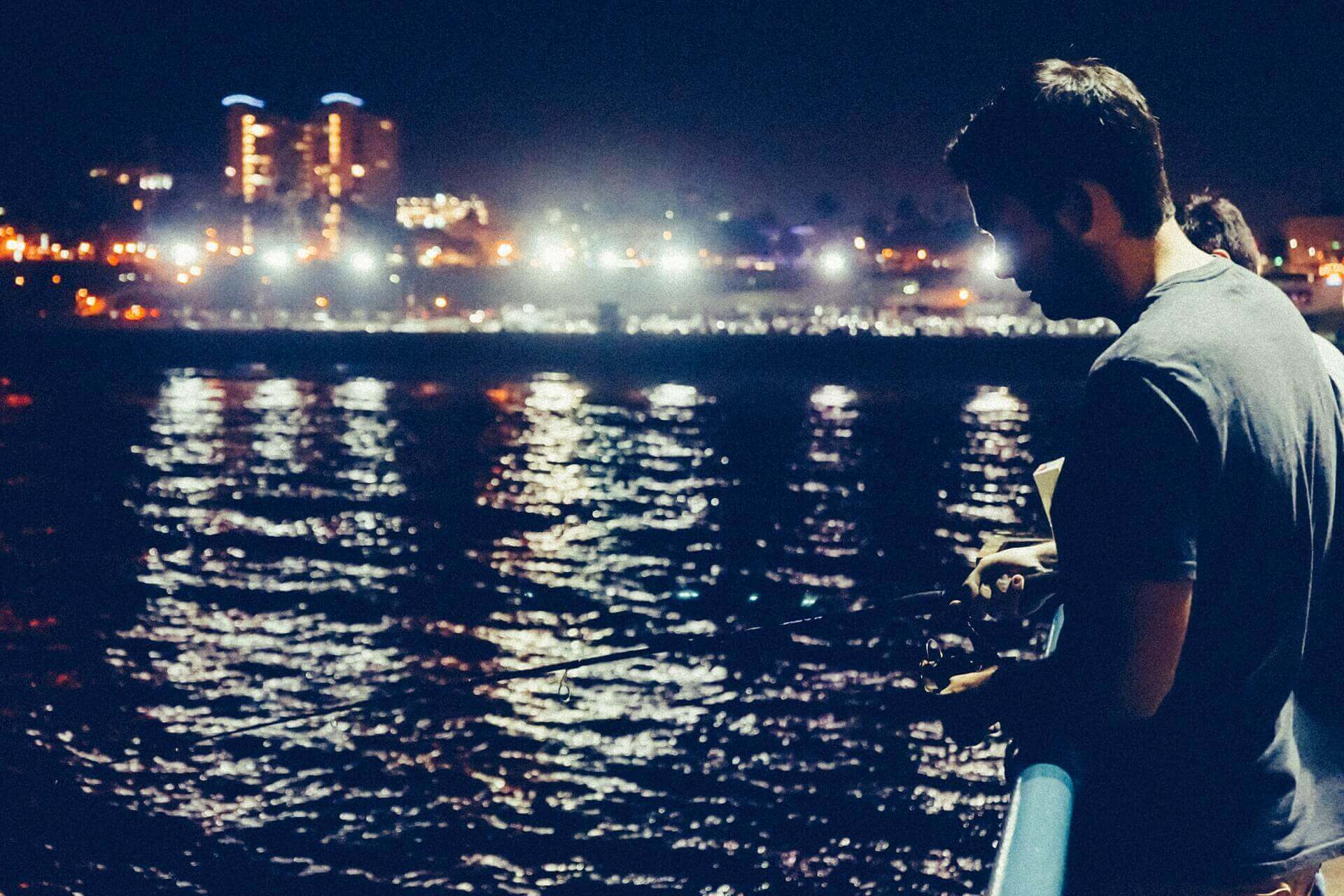 A man fishing at night