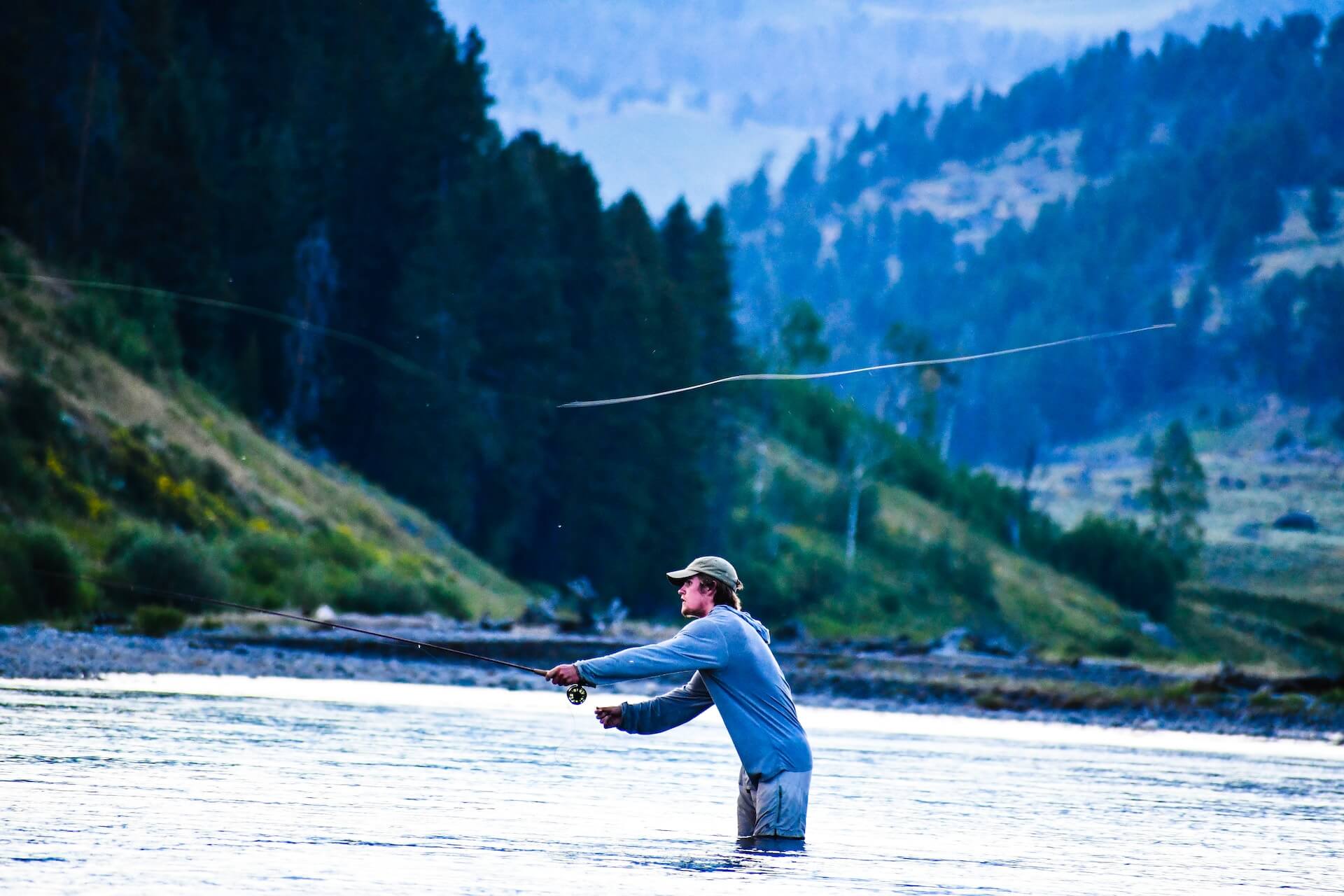 Man standing in water fly fishing