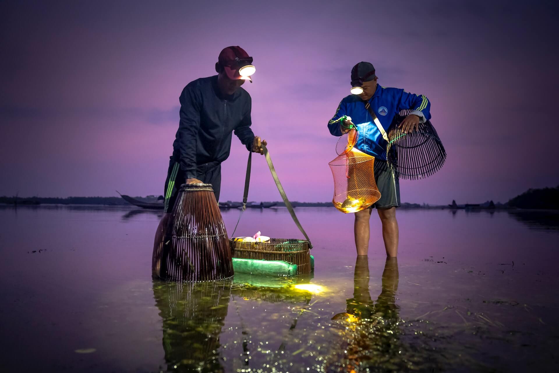 Men catching fish at night time