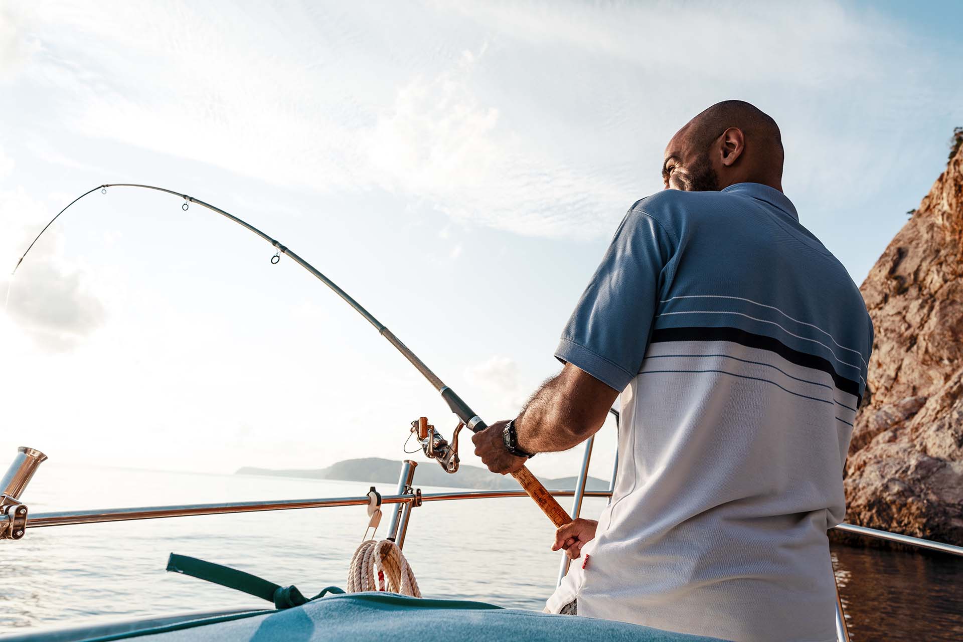 A man holding a fishing rod on a boat