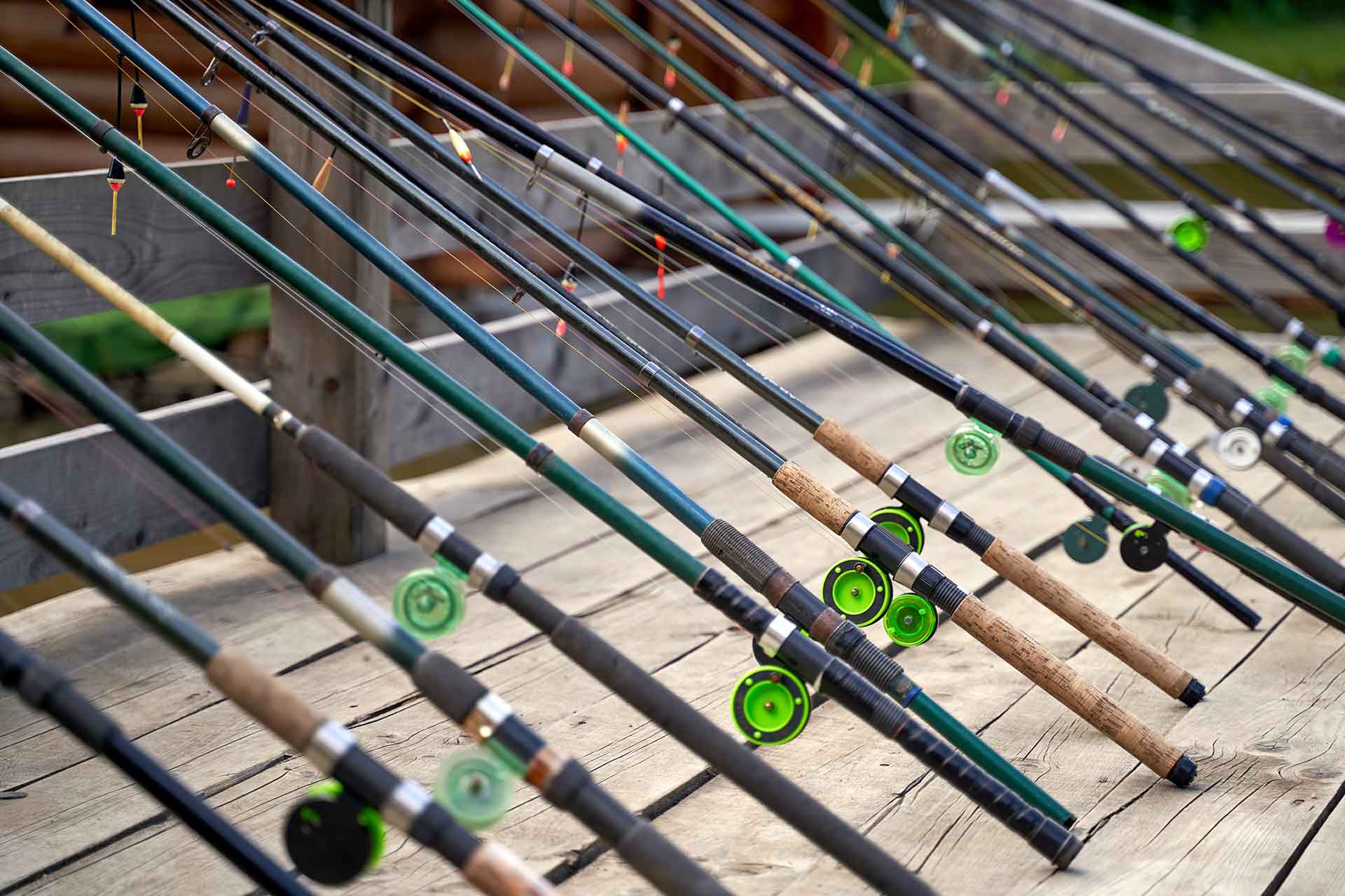 Many fishing rods on the wooden pier by the river or lake