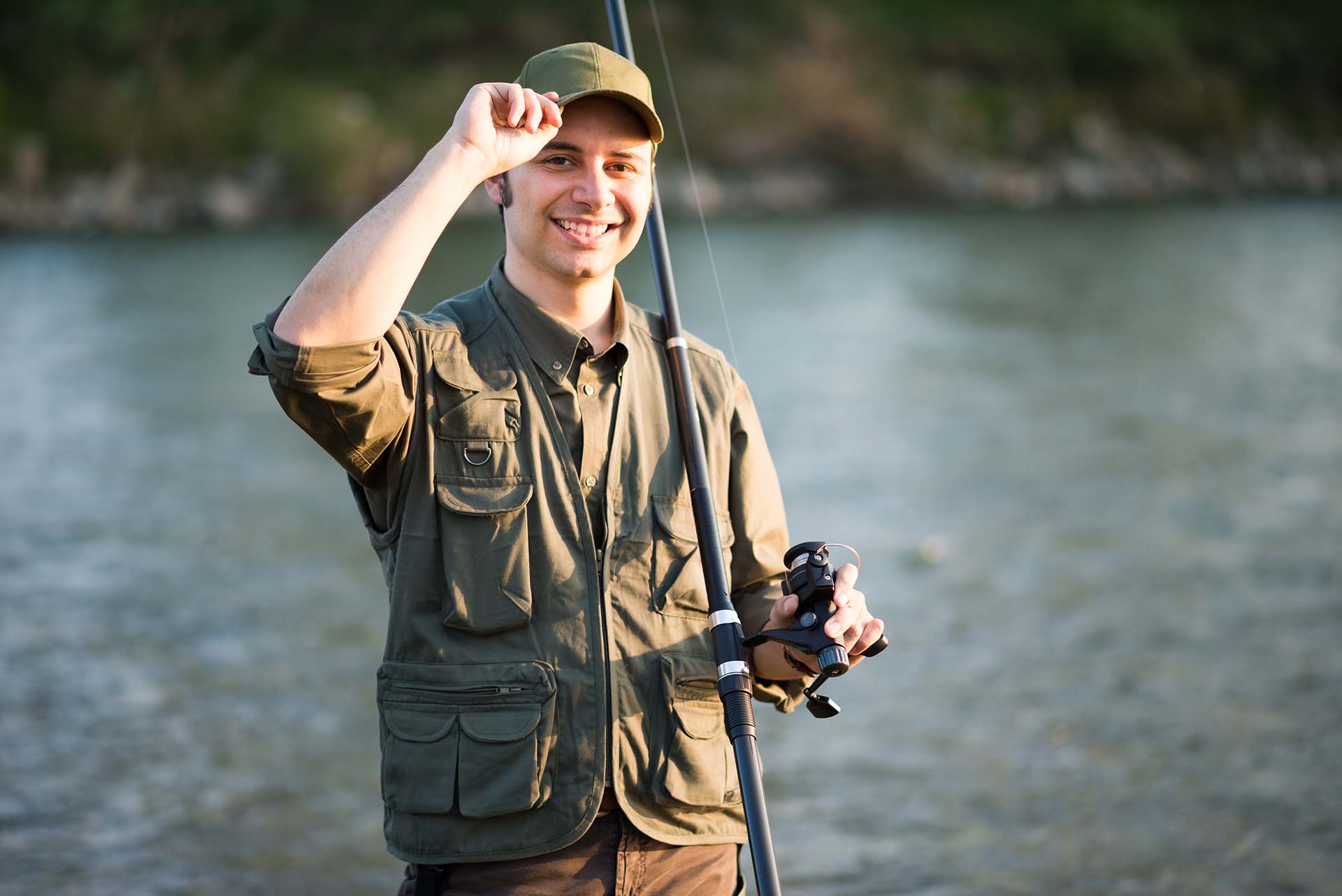 Portrait of a smiling fisherman fishing on a river