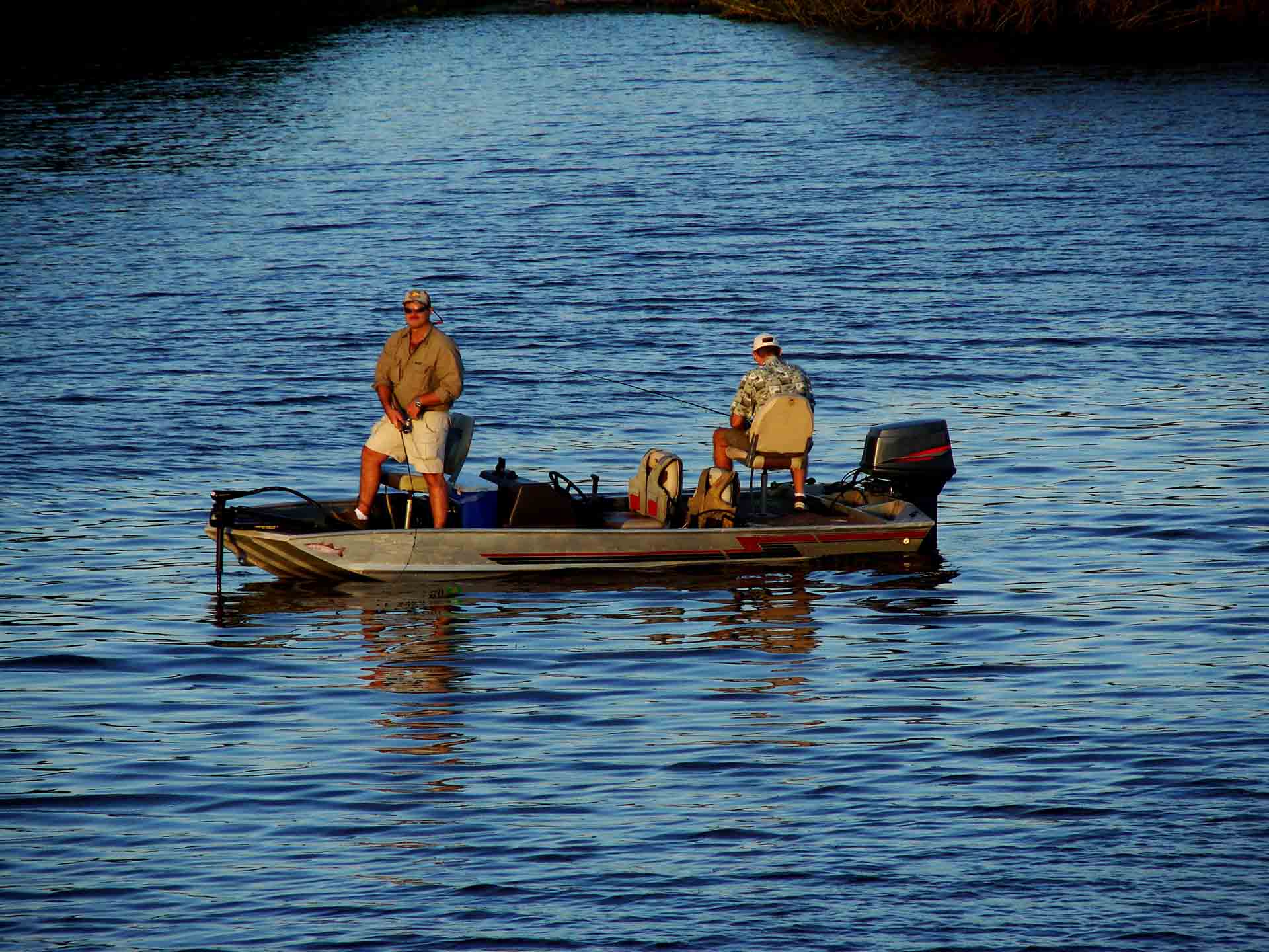 Two anglers fishing from a jon boat