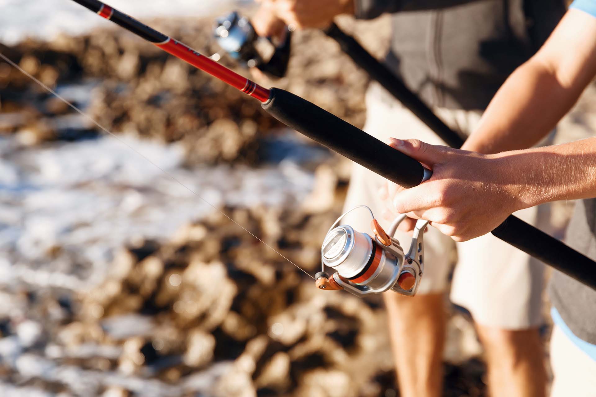 closeup of hands fishing with rod