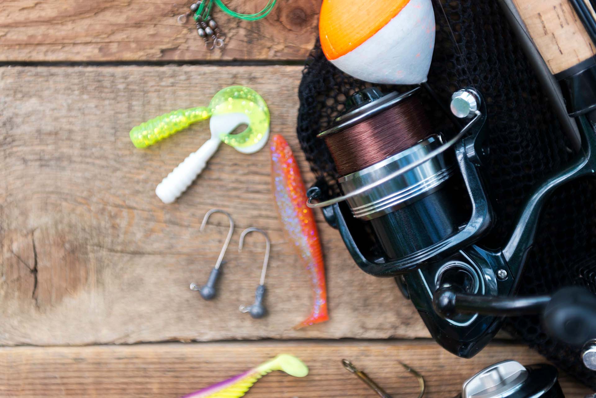 Close-up of baitcasting reel with two rubber bass lures