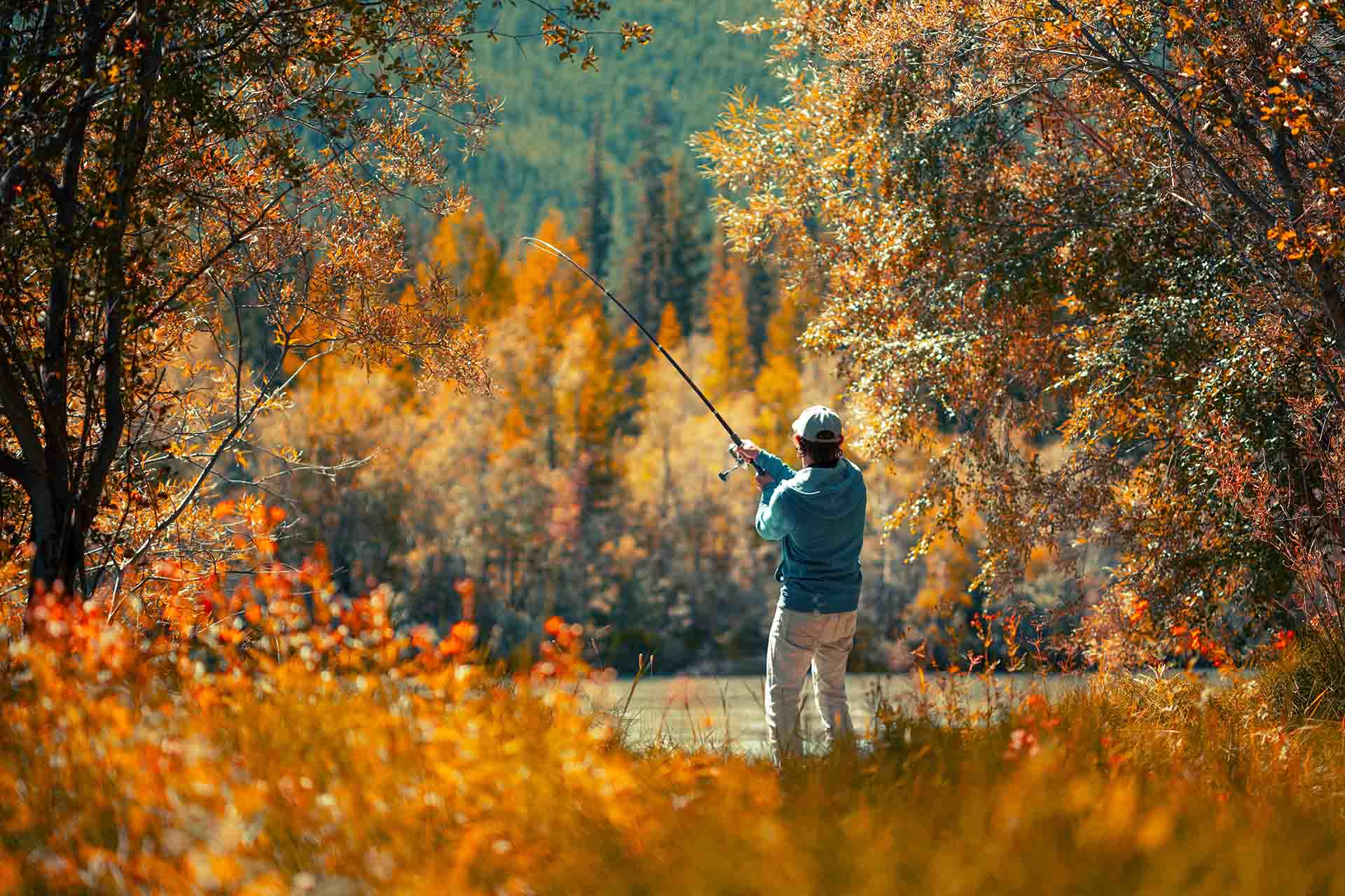 Angler fishing on the river during autumn