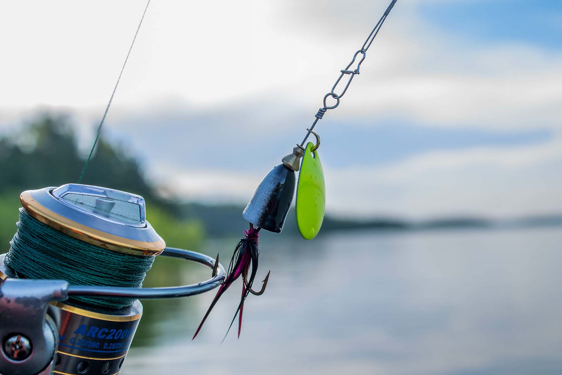 fishing spinning lure on fishing reel at the lake