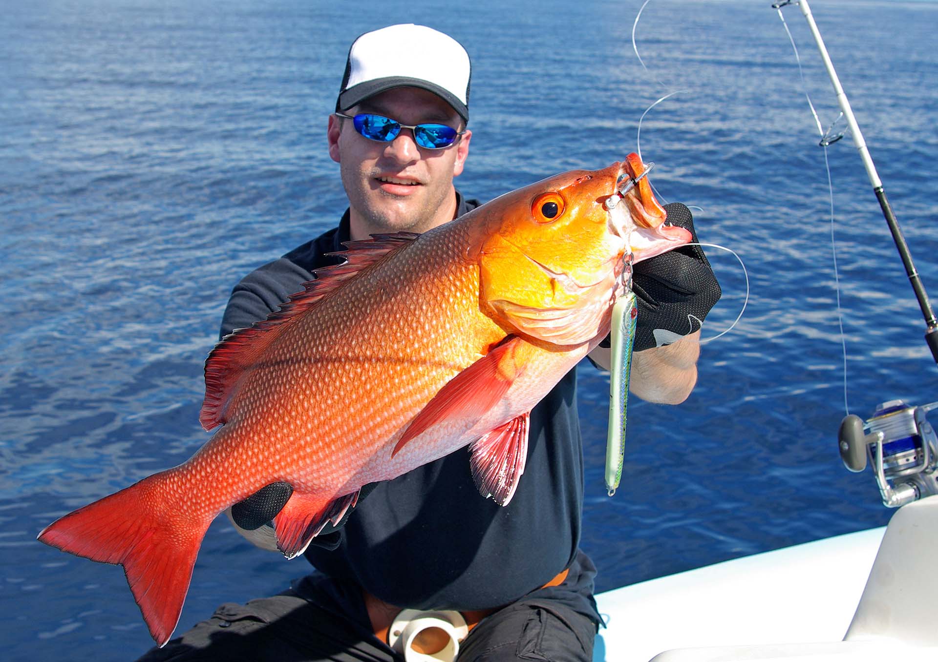 A happy fisherman holding a red snapper