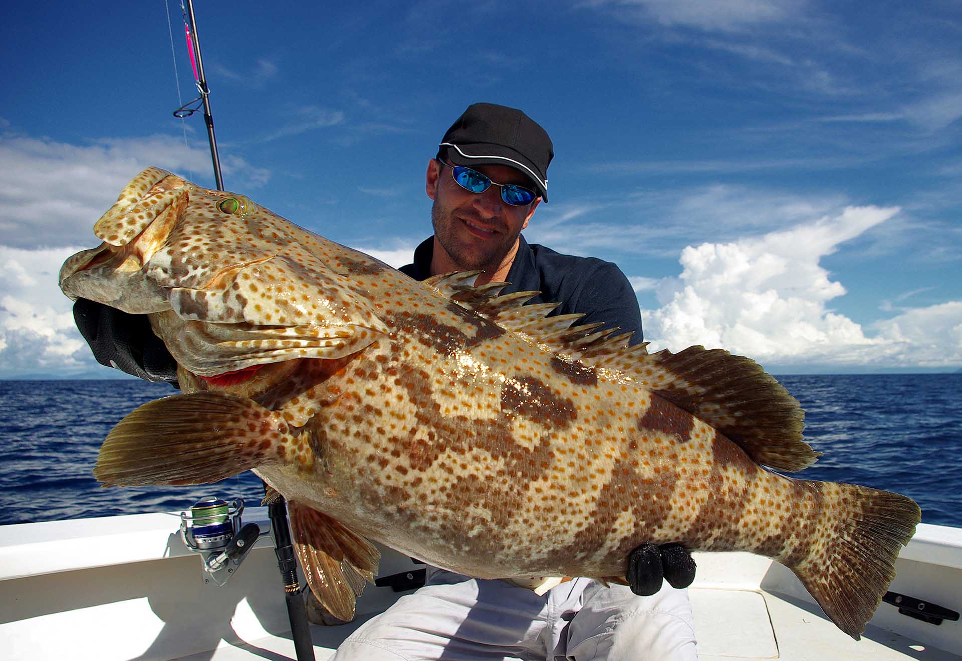 Happy fisherman holding a grouper