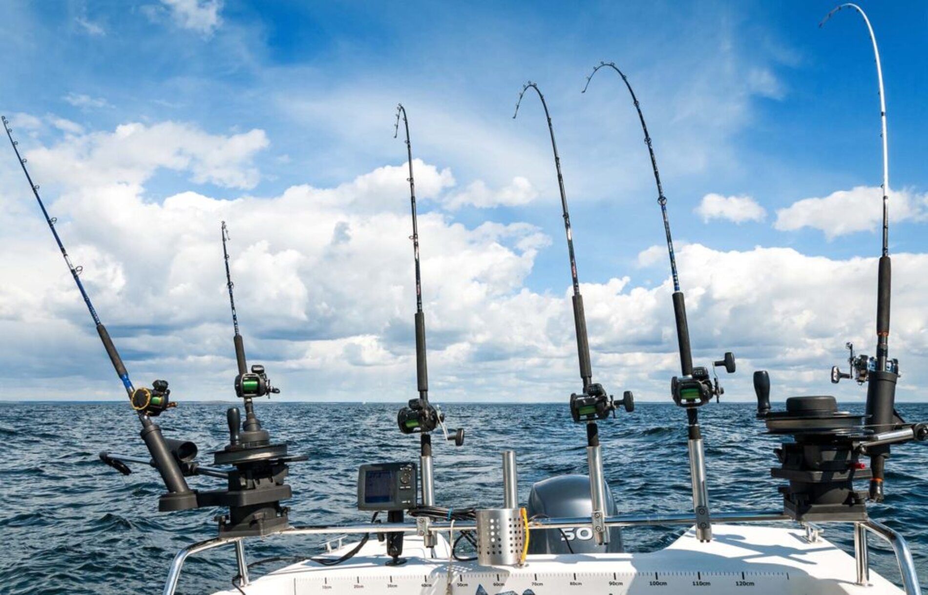 Fishing rods on the back of a boat used for trolling on the sea