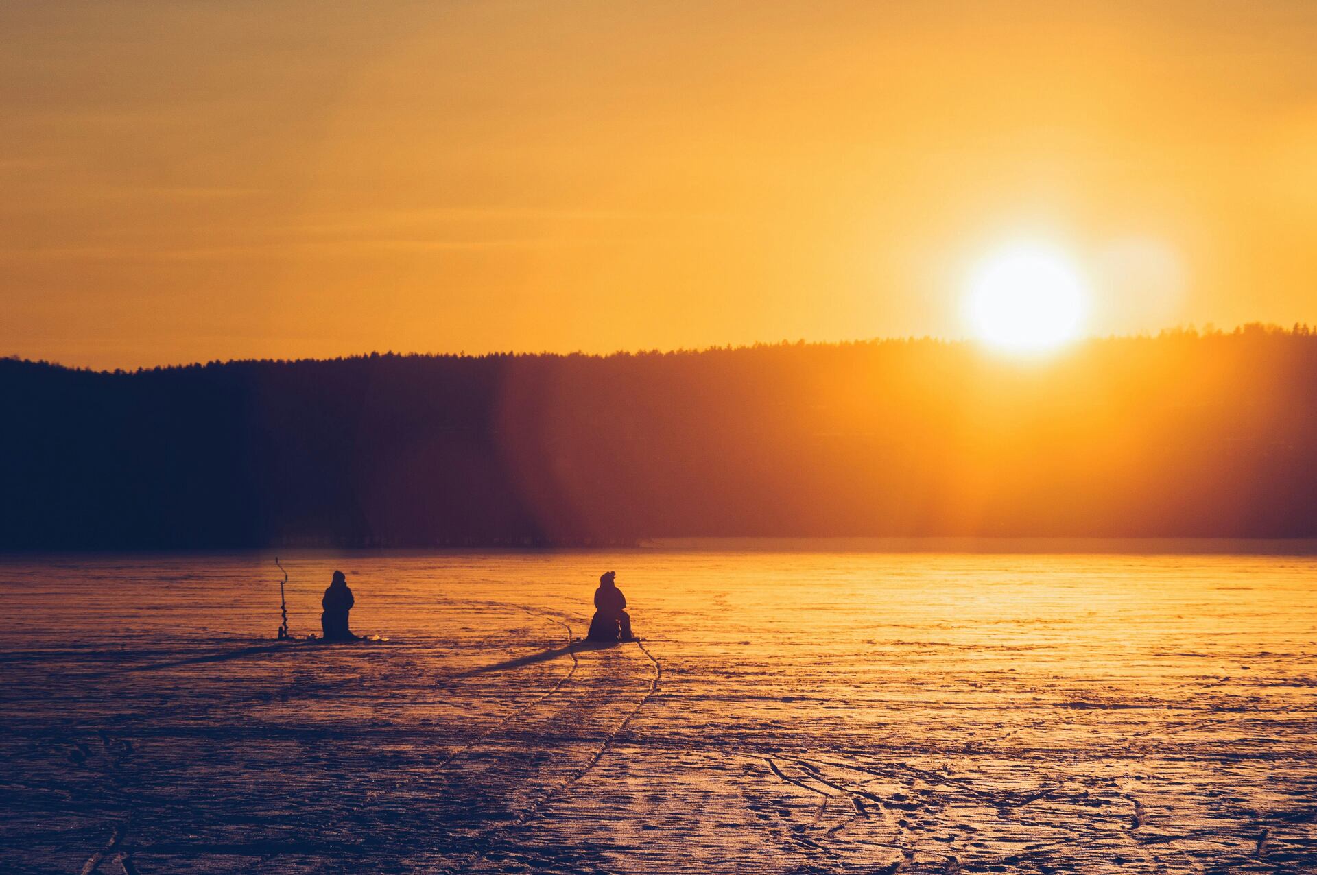 People ice fishing at dawn