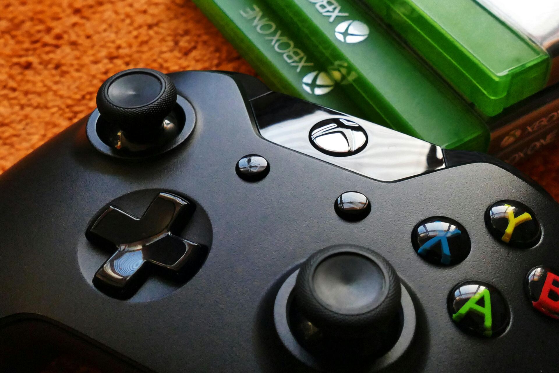 A close-up of an Xbox controller with three cases besides