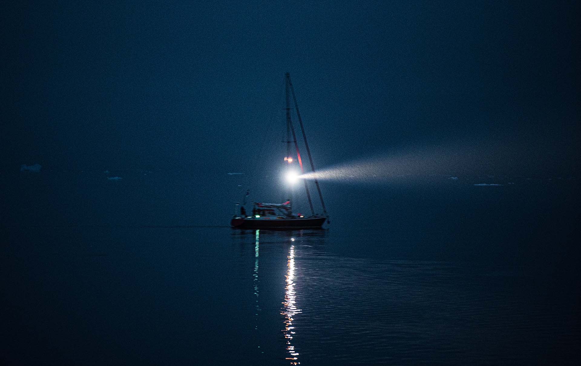 A fishing boat with the light on during the night