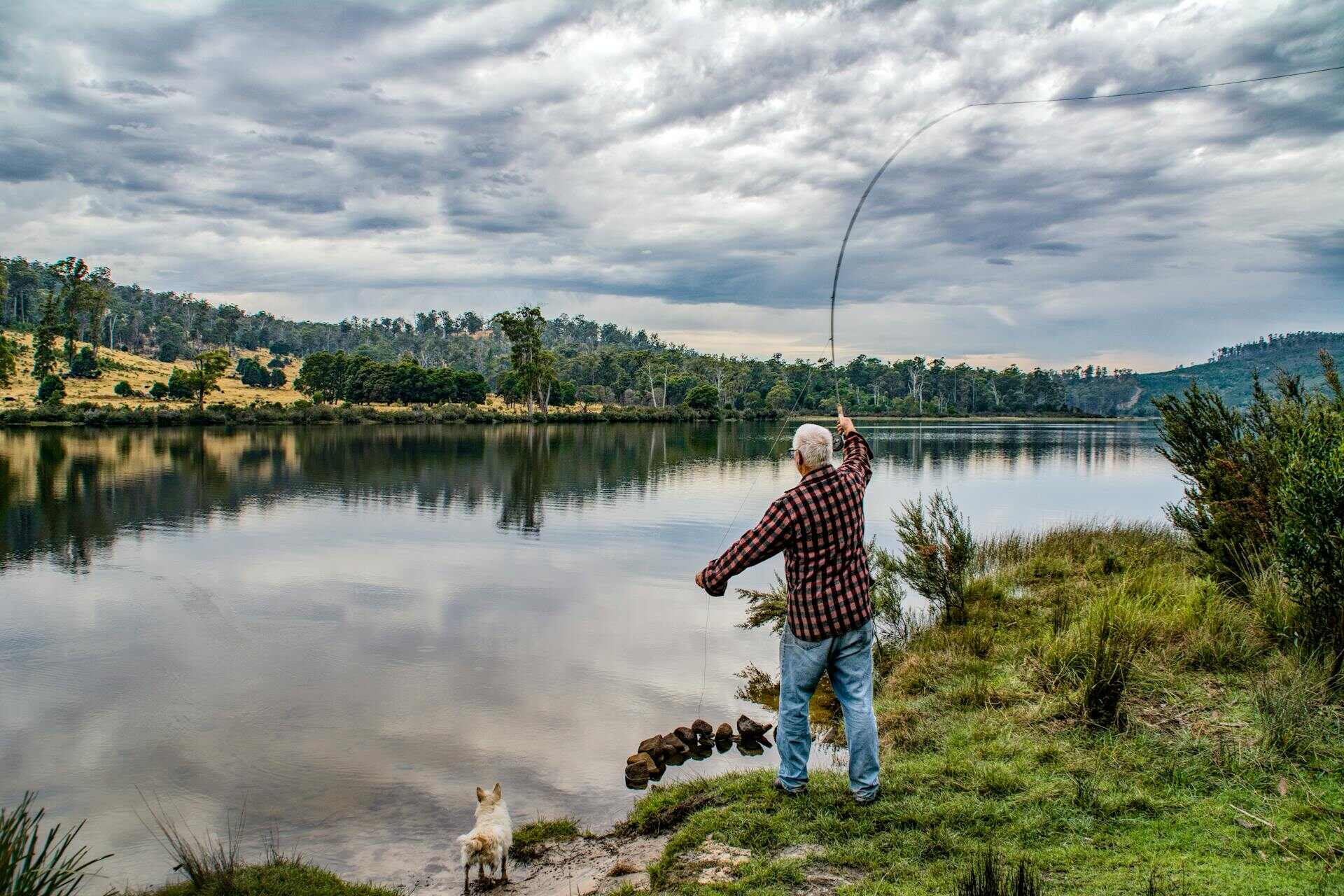 An older man casting a reel