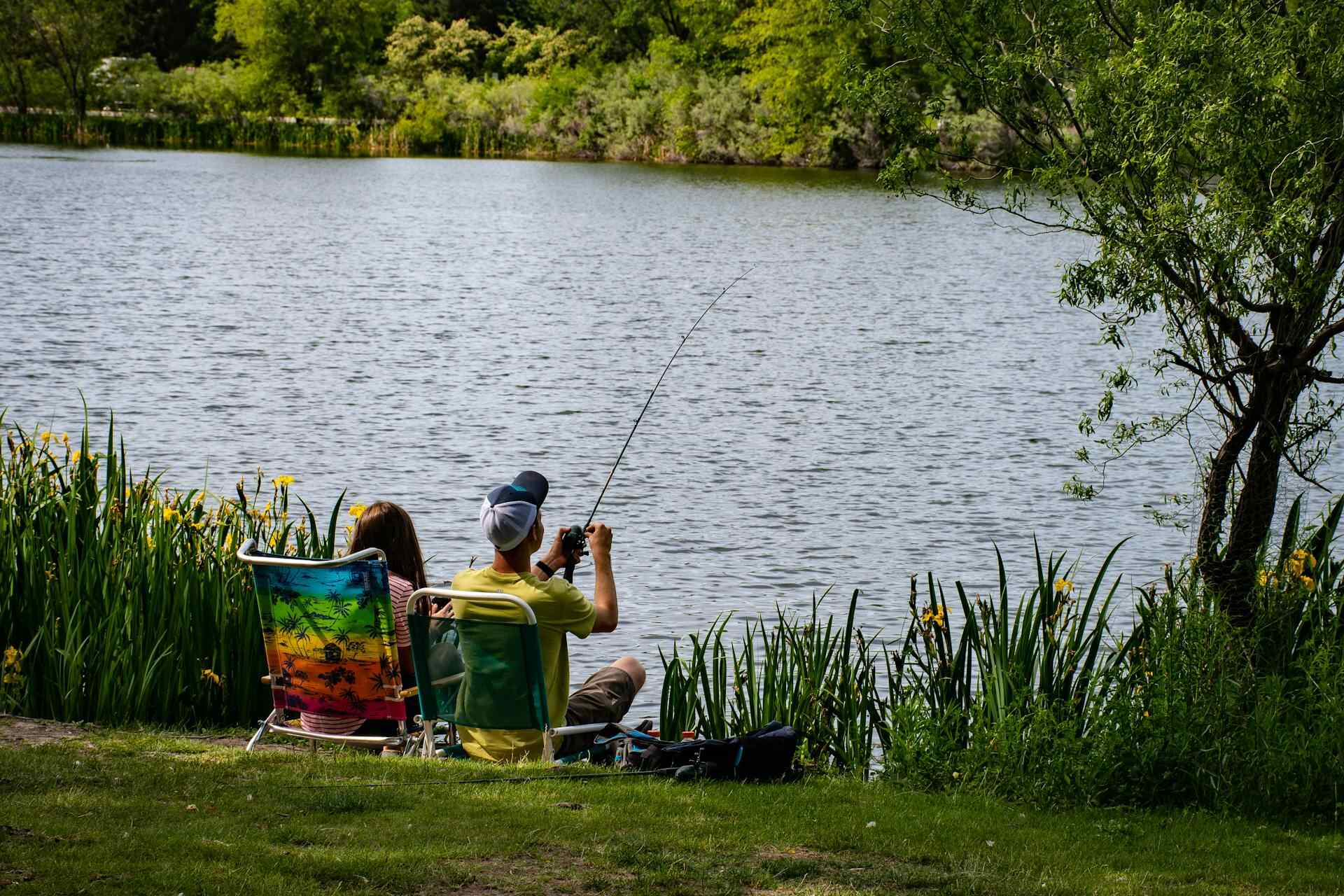 Two people fishing by the water