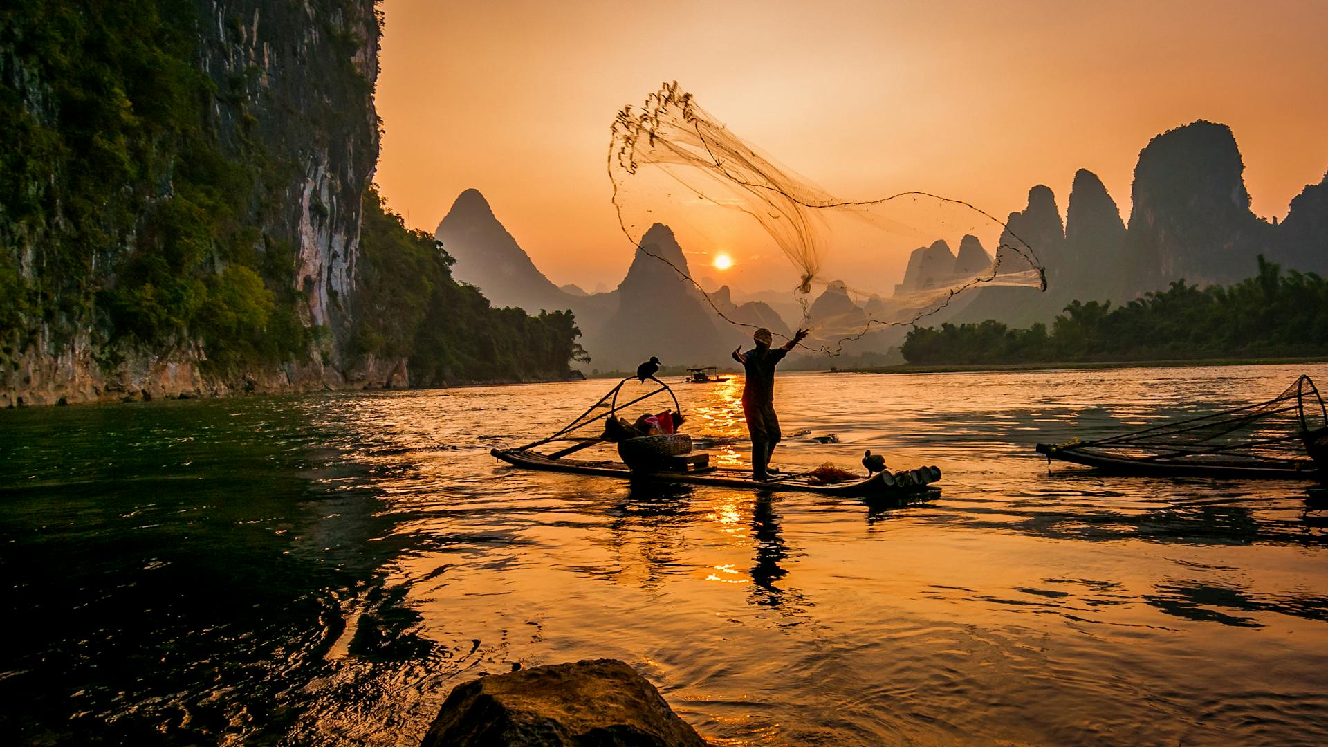 Fisherman throwing fishnet on water