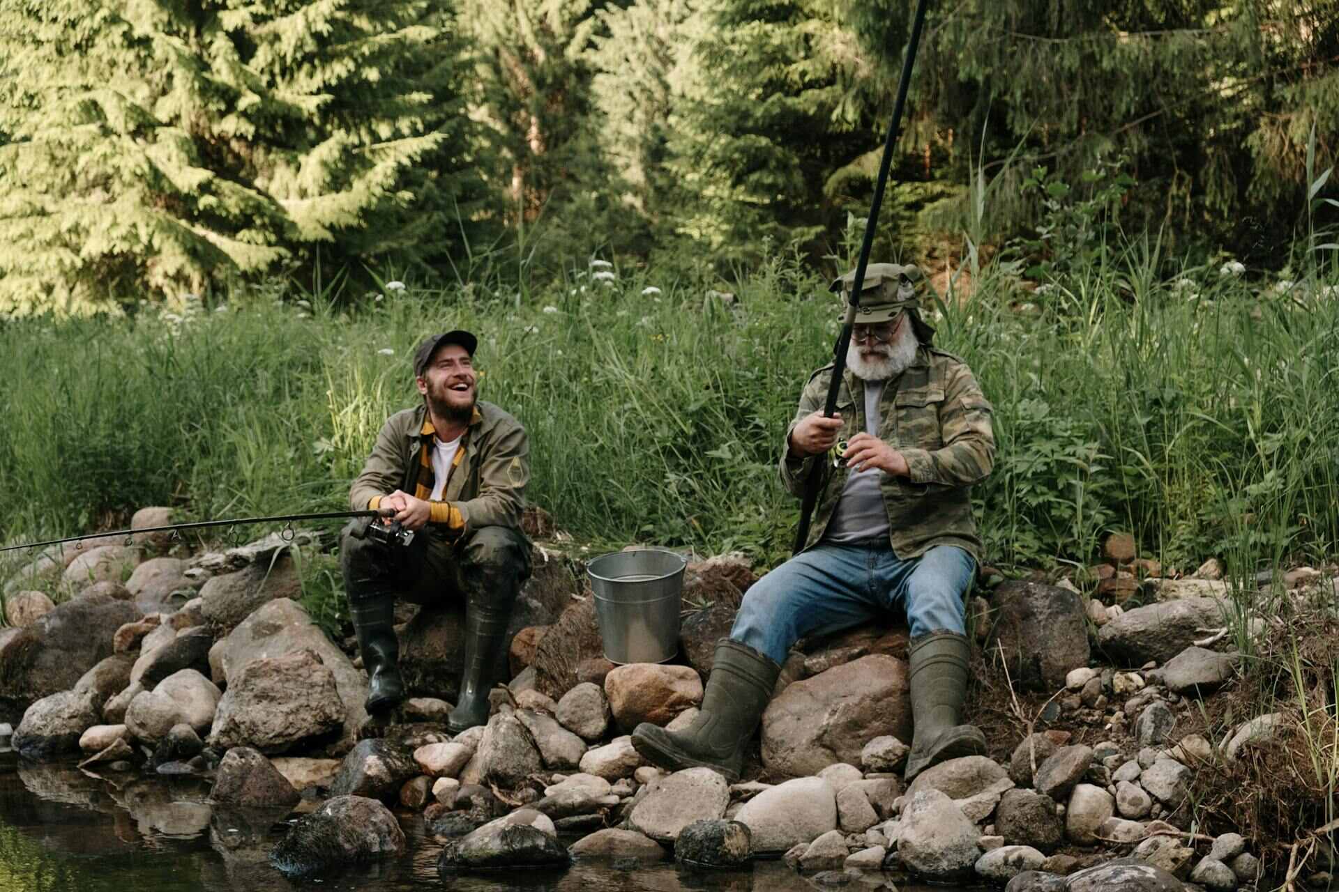 Two men sitting with angling rods